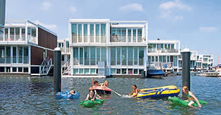 Children playing in the water near floating homes in IJburg, Amsterdam