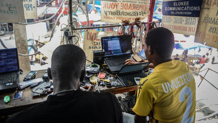 A man fixes a computer at the 'Computer Village', the bazaar where electronic products such as mobile phones, computer hardware and accessories are sold, in the Ikeja suburb of Lagos, Nigeria