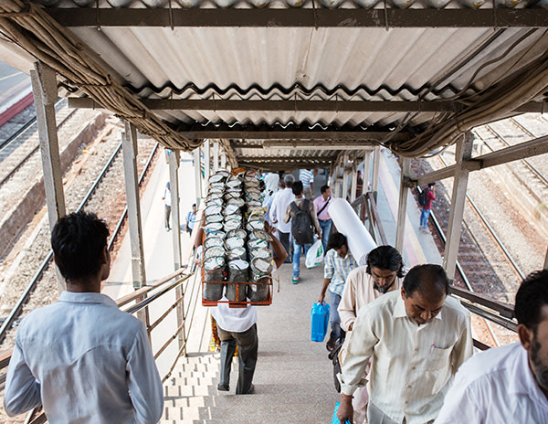 Dashrat Kedari carries tiffin boxes down the stairs at Santacruz station