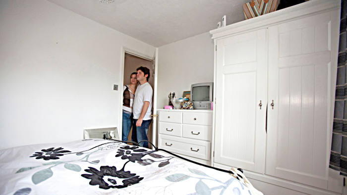 Illustrative image of a young couple looking around a house.