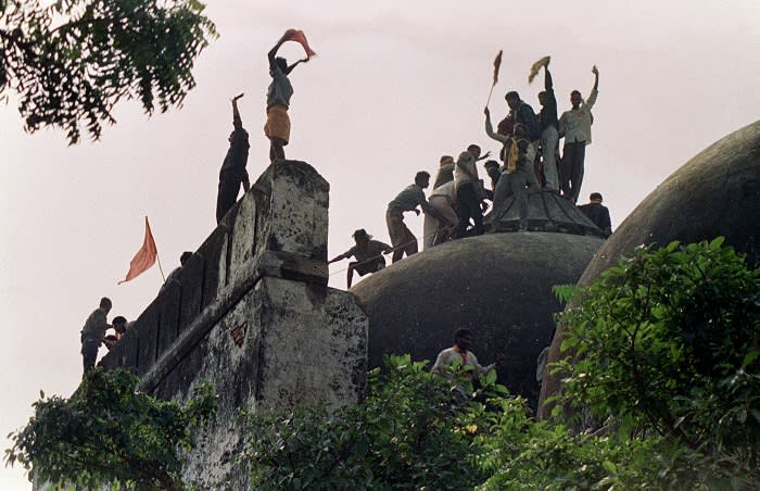 In this file photograph taken on December 6, 1992 Hindu youths clamour atop the 16th century Muslim Babri Mosque five hours before the structure was completely demolished by hundreds supporting Hindu fundamentalist activists. - An inquiry into the demolition of a mosque that led to bloody Hindu-Muslim riots in India will accuse senior Hindu nationalist politicians of orchestrating the destruction, a report said on November 23, 2009. The Bharatiya Janata Party (BJP) party stalled business in parliament over claims in the Indian Express newspaper that an official probe into the razing of the 16th-century Babri Mosque in 1992 "indicted" the party's leaders. AFP PHOTO/DOUGLAS E CURRAN/FILES (Photo credit should read DOUGLAS E. CURRAN/AFP/Getty Images)