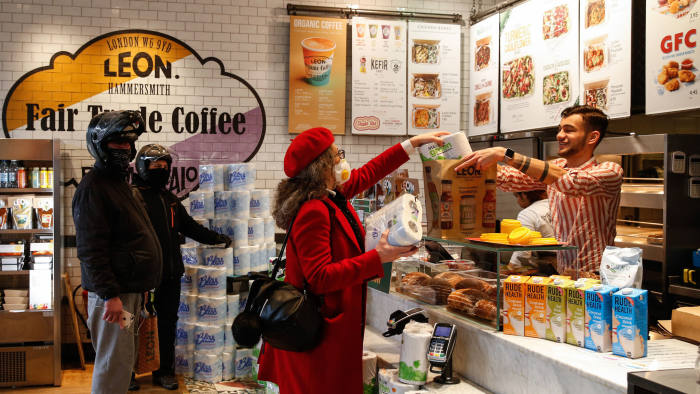 A customer purchases toilet roll from a Leon Restaurants Ltd. fast food outlet, as they have adapted their business to support their supply chain and the local community during the coronavirus pandemic, in London, U.K., on Wednesday, March 25, 2020. Britain's lockdown to curb the coronavirus pandemic has ignited demand at hypermarkets and turbo-charged a shift to online buying as consumers rush to stockpile while keeping their distance from fellow shoppers. Photographer: Hollie Adams/Bloomberg via Getty Images