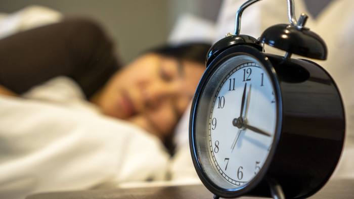 girl sleeping on bed,alarm clock at bedside