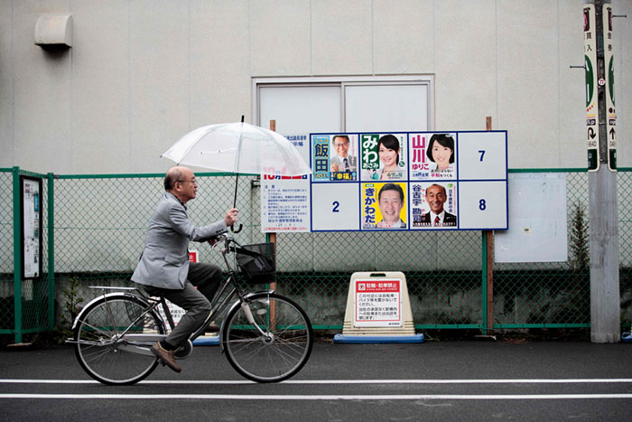 TOPSHOT - A man walks past electoral posters of Japanese candidates for the upcoming general election in Koshigaya city, Saitama prefecture, on October 20, 2017. A typhoon is expected to lash Japan with heavy rains on October 22, potentially weighing on turnout as millions of voters head to the polls in the world's third-biggest economy. / AFP PHOTO / Behrouz MEHRIBEHROUZ MEHRI/AFP/Getty Images