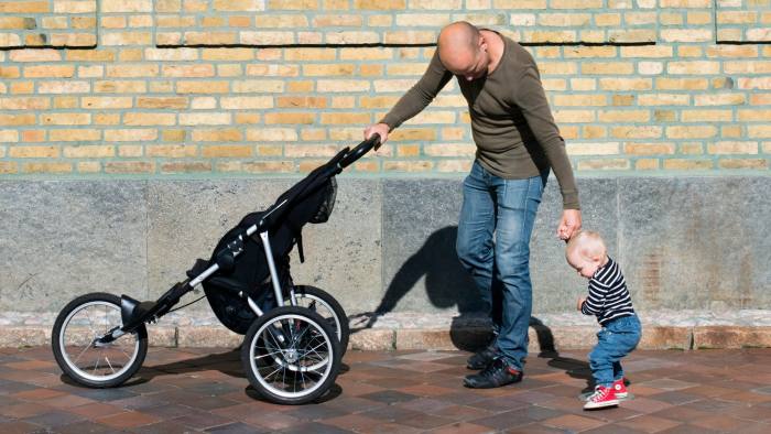 HY33DW Father and baby son (12-17 months) walking with stroller