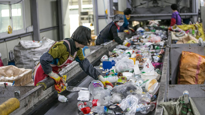 Employees of Taeseo Recycling Co. Ltd. sort plastic waste among the mix of waste in its recycling facility in Gwangmyeong, South Korea, on Thursday, April 19, 2018. The household recycling waste arrives here first, and the employees sort them into recyclable and non-recyclable plastic waste. The plastic recyclable waste is pressed into a block and sent to another facility that processes them into flakes. China's new policy on importing recyclable waste bans importing plastic flakes as well since January this year. Photographer: Jean Chung/Bloomberg