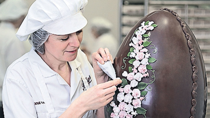A handmade egg is decorated at Bettys Craft Bakery