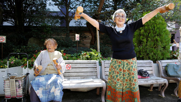 Natsu Naruse (L), 100 year-old, and other partcipants exercise with wooden dumbbells during a health promotion event to mark Japan's "Respect for the Aged Day" at a temple in Tokyo's Sugamo district, an area popular among the Japanese elderly, Japan, September 18, 2017.   REUTERS/Toru Hanai - RC1C20FDDEC0