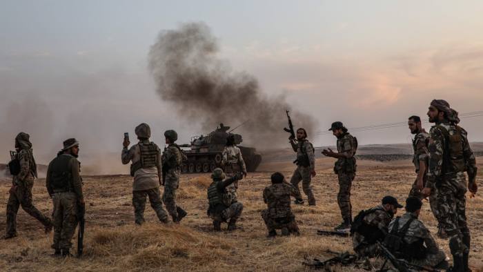 TOPSHOT - Turkish soldiers and Turkey-backed Syrian fighters gather on the northern outskirts of the Syrian city of Manbij near the Turkish border on October 14, 2019, as Turkey and its allies continue their assault on Kurdish-held border towns in northeastern Syria. - Turkey wants to create a roughly 30-kilometre (20-mile) buffer zone along its border to keep Kurdish forces at bay and also to send back some of the 3.6 million Syrian refugees it hosts. (Photo by Zein Al RIFAI / AFP) (Photo by ZEIN AL RIFAI/AFP via Getty Images)