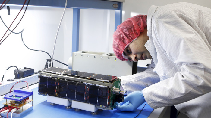 Spacecraft hardware engineer Anubhav Thakur performs a test on one of Spire's Lemur 2-2.0 satellites during a tour of Spire's nano-satellite facility in San Francisco, California 