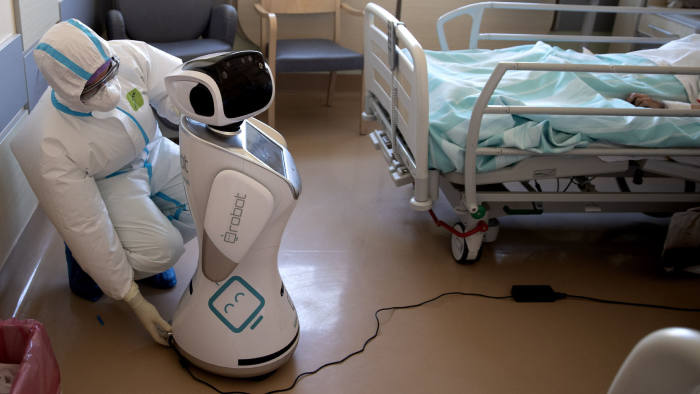 Deputy head of the intensive care unit Flavio Tangian, prepares a robot at 'Ospedale di Circolo' hospital, in Varese, Italy, Wednesday, April 8, 2020. Six robots will help healthcare professionals assist Covid-19 patients, one robot for every two patients to maximize monitoring and assistance. The new coronavirus causes mild or moderate symptoms for most people, but for some, especially older adults and people with existing health problems, it can cause more severe illness or death. (AP Photo/Luca Bruno)