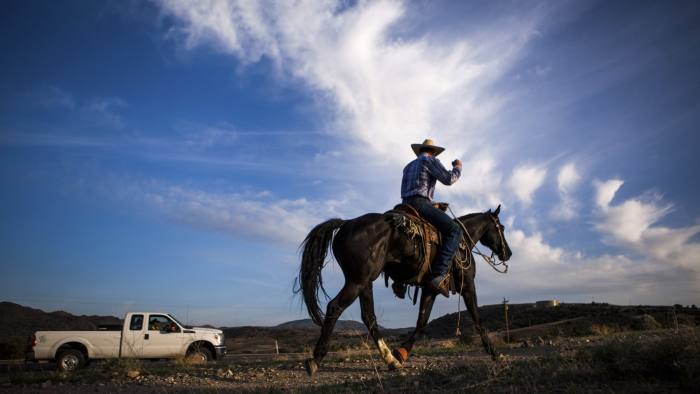 Bart Steninger salutes a member of their caravan during a 320-mile relay horseback ride from Elko, Nevada to the State Capitol in Carson City to deliver a petition to Governor Brian Sandoval, May 29, 2014. The ranchers want Sandoval?s help in ousting a regional Bureau of Land Management official whose office in northern Nevada has reduced by 20 percent the number of cattle allowed to graze over the next 12 months in the Battle Mountain region east of Carson City, citing lingering drought. Picture taken May 29, 2014. REUTERS/Max Whittaker (UNITED STATES - Tags: POLITICS BUSINESS AGRICULTURE ENVIRONMENT) - RTR3RLC3
