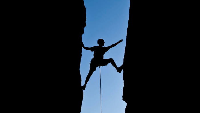 BAYFNF Rock climber silhouetted as he climbs up a chimney