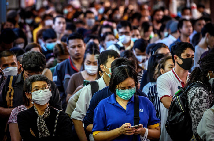 TOPSHOT - Commuters, wearing facemasks amid fears of the spread of the COVID-19 novel coronavirus, wait for a canal boat in Bangkok on March 2, 2020. - A Thai man has died from complications doctors say were due to the deadly coronavirus, though health officials were reluctant on March 2 to conclusively confirm the cause of his death. (Photo by Mladen ANTONOV / AFP) (Photo by MLADEN ANTONOV/AFP via Getty Images)