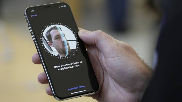 FILE - In this Friday, Nov. 3, 2017, file photo, an Apple employee demonstrates the facial recognition feature of the new iPhone X at the Apple Union Square store in San Francisco. The iPhone X's lush screen, facial-recognition skills and $1,000 price tag are breaking new ground in Apple's marquee product line. (AP Photo/Eric Risberg, File)