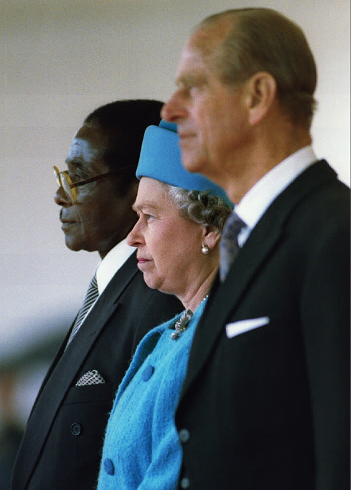 Queen Elizabeth II and the Duke of Edinburgh stand with President of Zimbabwe Robert Mugabe (L) shortly before he reviewed a guard of honour May 17 - PBEAHUNGRCF