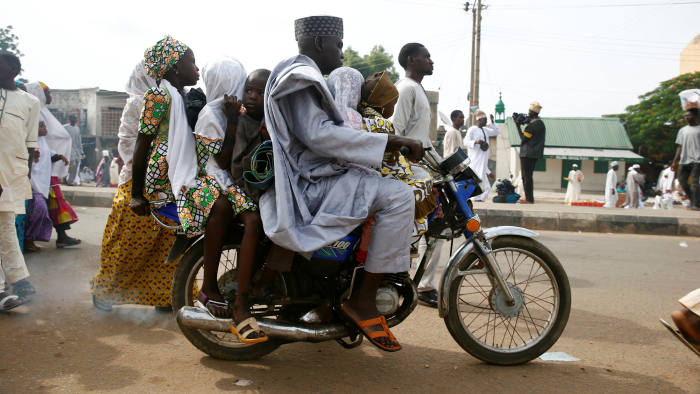 A man leaves with his children on a motocycle after attending the Eid al-Fitr prayers at Kofa Mata praying ground, to mark the end of holy month of Ramadan, in Nigeria's northern city of Kano, July 6, 2016.REUTERS/Akintunde Akinleye - RTX2JYIO