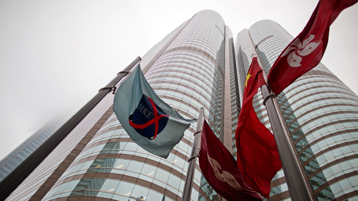 The flag of the Hong Kong Exchanges and Clearing Ltd. (HKEx), left, flies from a mast outside the Stock Exchange buildings in Hong Kong, China