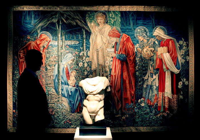 A Christie's employee stands in front of a 1904 tapestry by Sir Edward Coley Burne-Jones and a 1st-2nd century marble torso on January 29, 2009 in London. The private collection of Yves Saint Laurent and Pierre Berge is on show in London and will be sold at auction in Paris from 23rd to 25th February 2009.