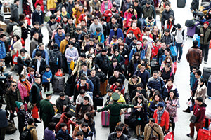 People wait in line to board their trains ahead of Chinese new year