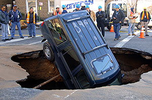 A Ford Explorer sits nose-first inside a 15-foot-by-20-foot-wide sinkhole