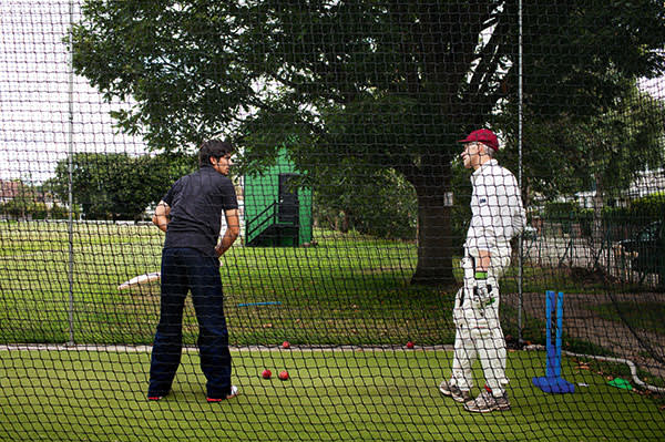 Alistair Cook, captain of the England Cricket Team, gives writer, Tom Holland a masterclass in cricket batting at the Finchley Cricket Club in north London. Here Alistair, left, teaches Tom, right, how to hit the ball in the training area at Finchley Cricket Club