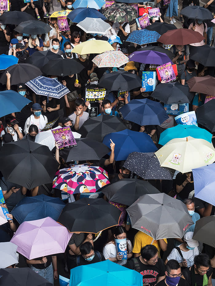 Protesters carrying umbrellas and wearing masks march from Causeway Bay to Admiralty last month, with many making gestures to police who were looking on