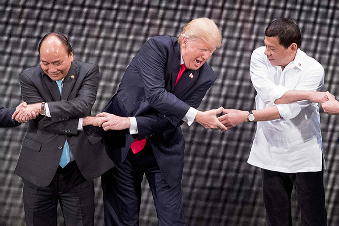 TOPSHOT - Vietnam's Prime Minister Nguyen Xuan Phuc (L), US President Donald Trump (C) and Philippine President Rodrigo Duterte join hands for the family photo during the 31st Association of South East Asian Nations (ASEAN) Summit in Manila on November 13, 2017. World leaders are in the Philippines' capital for two days of summits. / AFP PHOTO / JIM WATSONJIM WATSON/AFP/Getty Images