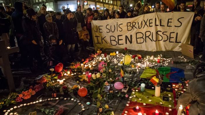 People hold a banner reading in French and Flamish "I AM BRUSSELS" as they gather around floral tributes, candles, belgian and peace flags and notes in front of the Bourse of Brussels on March 22, 2016 in tribute to the victims of Brussels following triple bomb attacks in the Belgian capital that killed about 35 people and left more than 200 people wounded. Belgium launched a huge manhunt on March 22 after a series of bombings claimed by the Islamic State group ripped through Brussels airport and a metro train, killing around 35 people in the latest attack to bring carnage to the heart of Europe. / AFP PHOTO / BELGA AND Belga / Aurore Belot / Belgium OUTAURORE BELOT/AFP/Getty Images