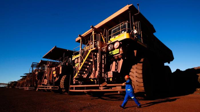 A driver passes a row of Komatsu Ltd. haul trucks at Sishen open cast mine, operated by Kumba Iron Ore Ltd., an iron ore-producing unit of Anglo American Plc, in Shishen, South Africa, on Wednesday, Aug. 24, 2011. Kumba Iron Ore Ltd. may decide on the next stage of its Sishen-Saldanha expansion in 2014, the company said in a presentation on its website today. Photographer: Nadine Hutton/Bloomberg