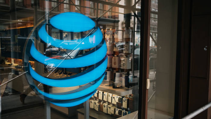 The AT&T Inc. logo is displayed outside a store in New York, U.S., on Wednesday, June 13, 2018. AT&T Inc.'s sweeping court victory allowing its takeover of Time Warner Inc. delivers a sharp setback to the Justice Department's new approach to policing mergers under President Donald Trump and promises to spark a merger wave across industries. Photographer: Christopher Lee/Bloomberg