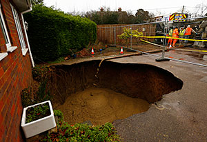 Concrete is poured into a 4.5 metre (15 feet) wide sinkhole on the driveway of a house in Walters Ash, southern England February 6, 2014