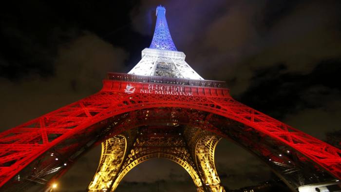 The Eiffel Tower is lit with the blue, white and red colours of the French flag in Paris, France, November 17, 2015, to pay tribute to the victims of a series of deadly attacks on Friday in the French capital. The City of Paris motto "Fluctuat Nec Mergitur", Latin for "buffeted (by waves) but not sunk" is projected on the Eiffel Tower. REUTERS/Jacky Naegelen TPX IMAGES OF THE DAY