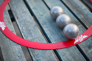 Pétanque metal balls and a red ring used to mark a player's position