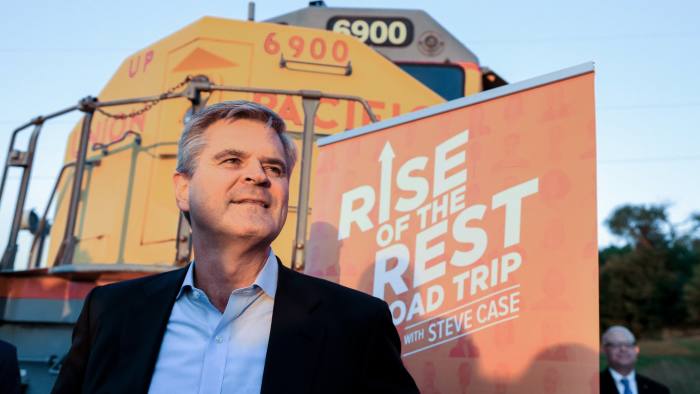 Entrepreneur Steve Case poses in front of a Union Pacific locomotive as he kicks off his "Rise of the Rest" startup bus tour at a stop in Omaha, Neb., Monday, Oct. 3, 2016. "Rise of the Rest" is a nationwide effort that works closely with and invests in entrepreneurs and emerging startups. (AP Photo/Nati Harnik)