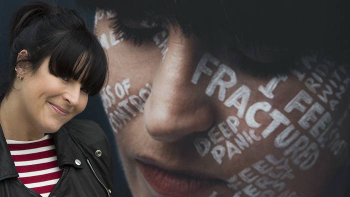 Anna Richardson stands next to a portrait of herself at an outdoor exhibition in RegentÕs Place in London, during the launch of the LetÕs Talk campaign, to encourage people to talk about mental health. PRESS ASSOCIATION Photo. Picture date: Monday October 8, 2018. By drawing peopleÕs most difficult thoughts on their faces, photographer Charlie Clift and lettering artist Kate Forrester hope to inspire others to open up about their own mental health. See PA story HEALTH Riley. Photo credit should read: David Mirzoeff/PA Wire