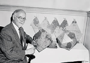 Professor Irving Fisher of Yale University, internationally famous economist, is shown  in New York, June 9, 1944.  He has devised a two-way map that may be folded into a globe or spread flat. Here, Prof. Fisher demonstrates the two uses or his novel map