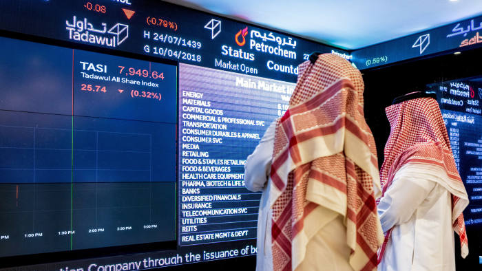 Visitors look at stock price information displayed on a digital screen inside the Saudi Stock Exchange, also known as the Tadawul, in Riyadh, Saudi Arabia, on Tuesday, April 10, 2018. Foreign investors bought more Saudi stocks in March than ever before in anticipation of the kingdom’s upgrade to emerging-market status. Photographer: Abdulrahman Abdullah/Bloomberg