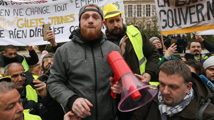 Maxime Nicolle (C), one of the eight epresentatives of the yellow vest (Gilet jaune) protestor movement, reads a letter to the President Macron during a demonstration called by the yellow vests (gilets jaunes) movement for the eighth week in a row of nationwide protest against high cost of living, government tax reforms and for more "social and economic justice" in front of the Town Hall of Paris on January 5, 2019. (Photo by Michel Stoupak/NurPhoto via Getty Images)