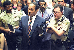 OJ Simpson tries on a pair of bloody gloves at the prosecution’s request during his trial in 1995 