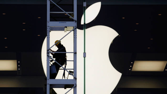 A worker climbs outside an Apple store in Hong Kong April 10, 2013
