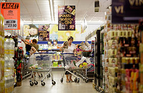 Customers push shopping carts along an aisle while shopping inside a Lidl discount supermarket store
