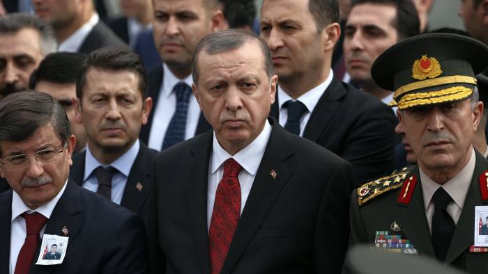 Turkey's President Recep Tayyip Erdogan, center, Prime Minister Ahmet Davutoglu, left, Chief of Staff Gen. Hulusi Akar, right, arrive to attend funeral prayers for army officer Seckin Cil, who was killed in Sur, Diyarbakir Wednesday, in Ankara, Turkey, Thursday, Feb. 18, 2016. Six soldiers were killed after PKK rebels detonated a bomb on the road linking the cities of Diyarbakir and Bingol in southeastern Turkey as their vehicle was passing by, according to Turkey’s state-run Anadolu Agency. The deaths come a day after a suicide bombing claimed the lives of at least 28 people and wounded dozens of others.(AP Photo/Burhan Ozbilici)