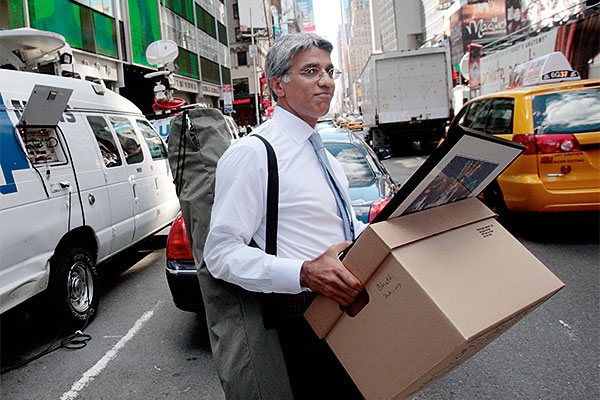 An employee of Lehman Brothers Holdings Inc. carries a box out of the company's headquarters building (background) September 15, 2008 in New York City