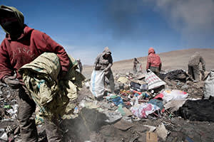 Residents searching a rubbish dump for items to sell