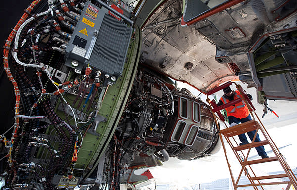 Boeing flight line mechanic Mike Feeney work on an engine of a Boeing 747-8 freighter