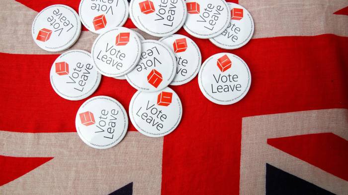 Vote Leave badges sit displayed on a Union Jack flag at a rally during the first day of a nationwide bus tour to campaign for a so-called Brexit in Exeter, U.K., on Wednesday, May 11, 2016. While online polls suggest the contest for the June 23 referendum is too close to call, less frequent telephone polling has put the "Remain" camp ahead. Photographer: Luke MacGregor/Bloomberg