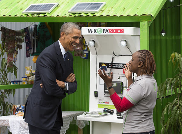 US President Barack Obama (L) talks with June Muli, head of Customer Care at M-Kopa, about solar power during the Power Africa Innovation Fair