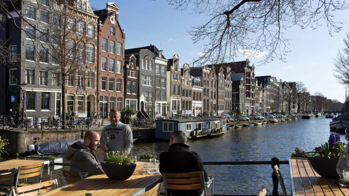 Men enjoy the afternoon sun at the Brouwersgracht canal in Amsterdam, April 2, 2013. REUTERS/Michael Kooren/File Photo - S1AETPSNOQAA