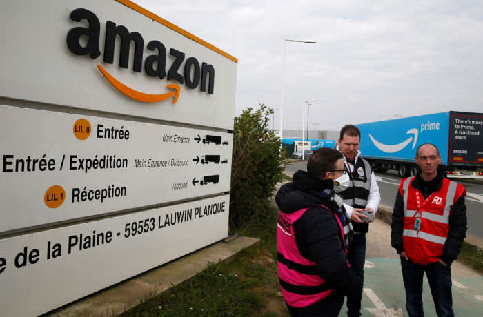 Amazon employees on strike gather outside the Amazon logistics center in Lauwin-Planque, northern France, March 19, 2020. Several hundred employees protested in France, calling on the U.S. e-commerce giant to halt operations or make it easier for employees to stay away during the coronavirus (COVID-19) epidemic. REUTERS/Pascal Rossignol